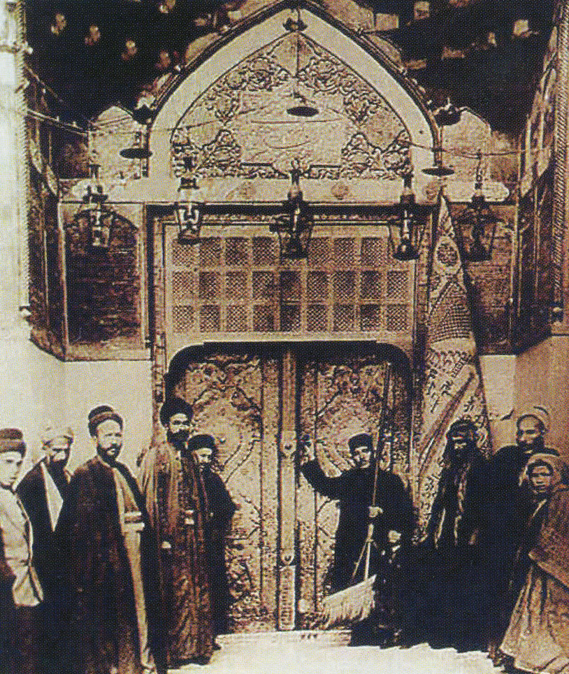 Hz. Ali'nin Kûfe'deki evi: Hz. Ali Cemel Savaşı'ndan sonra başkenti Medine'den Kûfe'ye taşıdı ve şehit edilinceye kadar orada ikamet etti. Hz. Ali'nin o dönemde yaşadığı mescidin yerine sonradan büyük bir cami inşa edildi. 1915 yılında çekilmiş bu fotoğrafta Hz. Ali'nin Kûfe Mescidi'nde bulunan evinin kapısı ve ziyaretçileri görülüyor. 